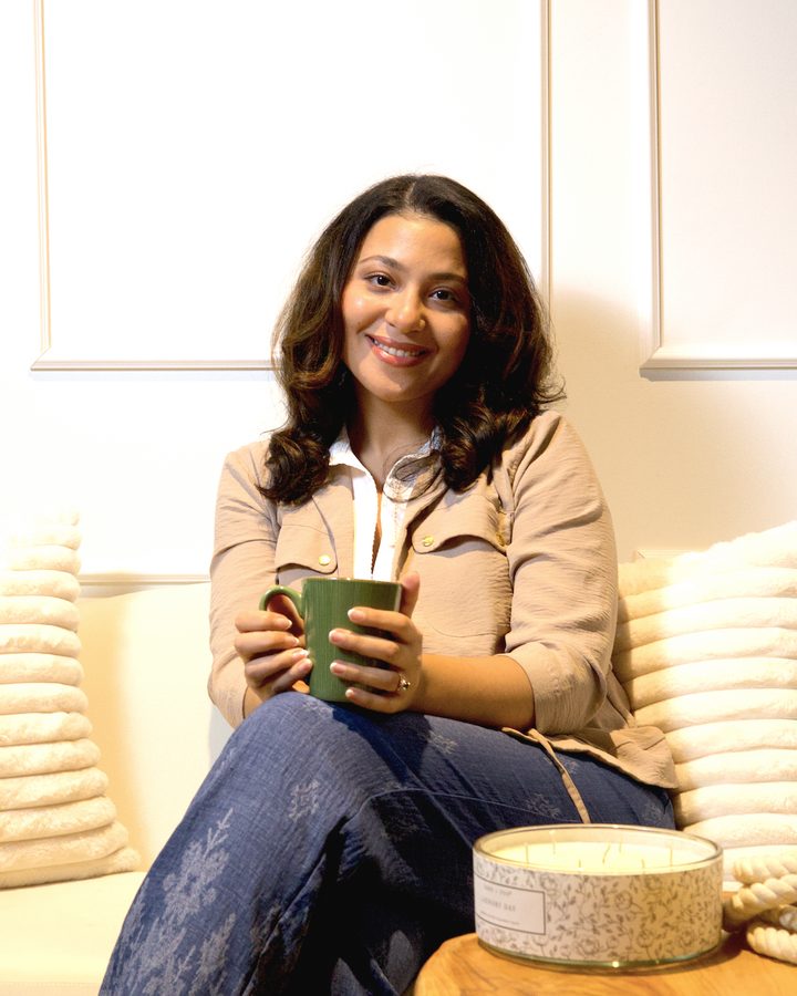 Hoda Ammar relaxing on a sofa with a cup of tea